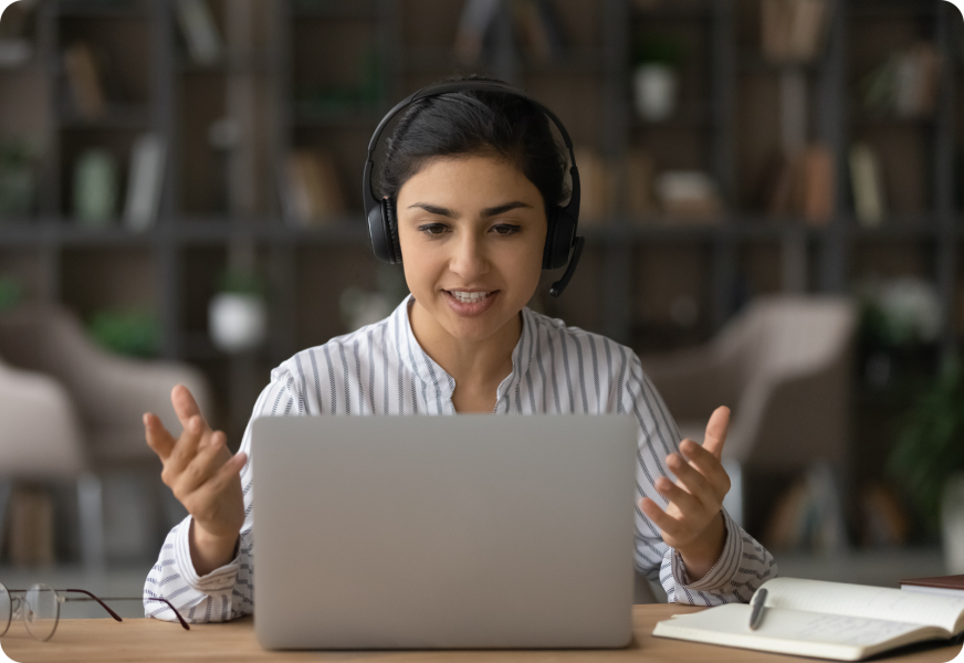 a person sitting at a table in front of a laptop